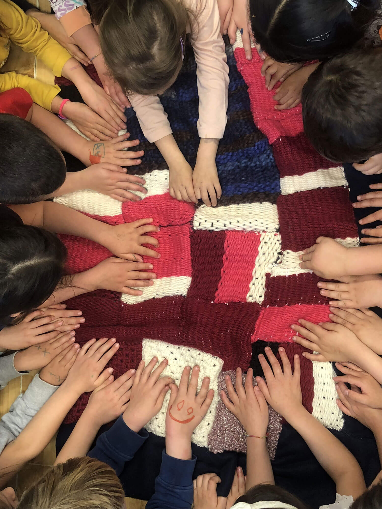 bambini_con_mani_su_coperta_di_lana